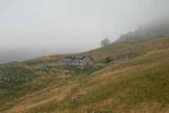 A farmhouse stands on the slopes of the Dolomite Alps of Italy