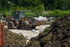 An end loader carries stone for the reconstruction of the Marge Cline Whitewater Course in Yorkville, IL