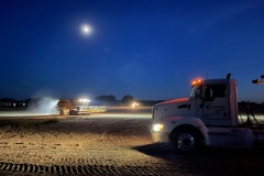 A combine harvester heads to a waiting truck to unload