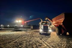 A grain cart prepares to offload corn in the front of the trailer as the combine offloads in the back