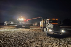 A combine harvester offloads soybeans directly into the transport truck